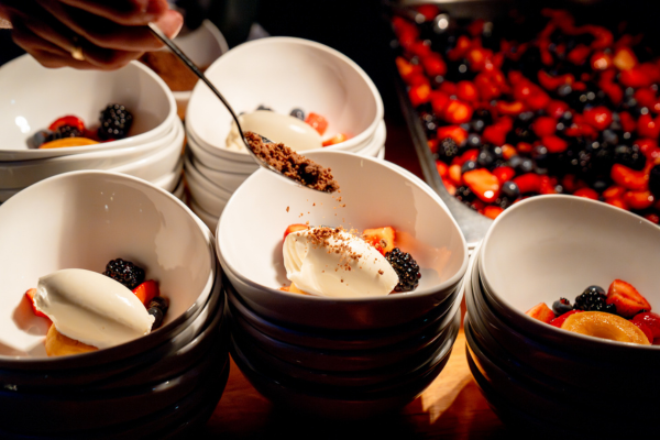 Dessertschalen mit Eis, Keksbröseln, Beeren und Minidonuts