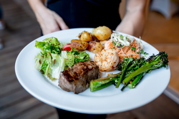 Teller mit Fleisch, Garnelen, Brokkoli, Kartoffeln und Salat